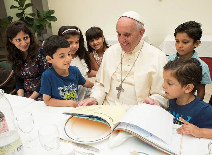 Pope Francis sits with refugee children from Syria at the Vatican Aug. 11. (CNS photo/L'Osservatore Romano via Reuters) 