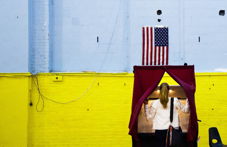 A woman enters a voting booth in Hoboken, N.J., June 7. (CNS photo/Justin Lane, EPA) 