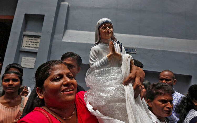 A woman holds a statuette of Mother Teresa outside the Missionaries of Charity building in Kolkata, India, Sept. 4. (CNS photo/Rupak De Chowdhuri, Reuters)