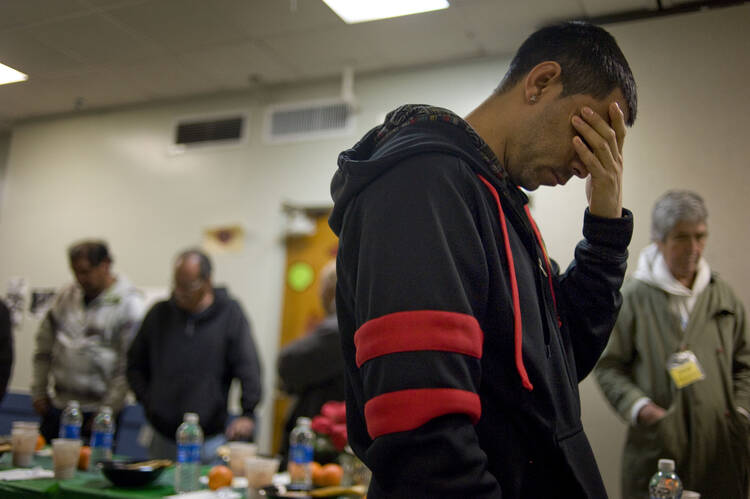 A man prays before dinner in 2014 at the Guadalupanos Homeless Project in Los Angeles. (CNS photo/David Maung, EPA) 