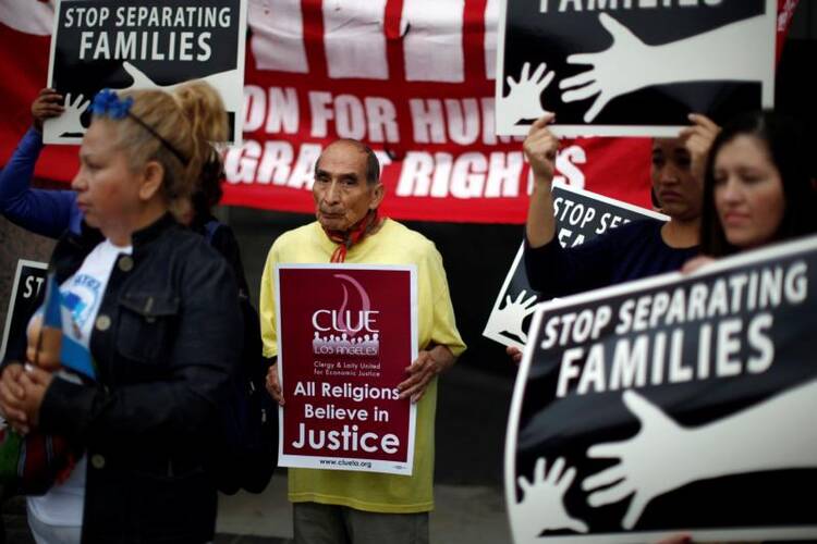 People hold signs in late May during a protest in Los Angeles against plans to deport Central American asylum seekers. Catholics and other faith leaders Sept. 28 called for action on immigration reform. (CNS photo/Lucy Nicholson, Reuters)