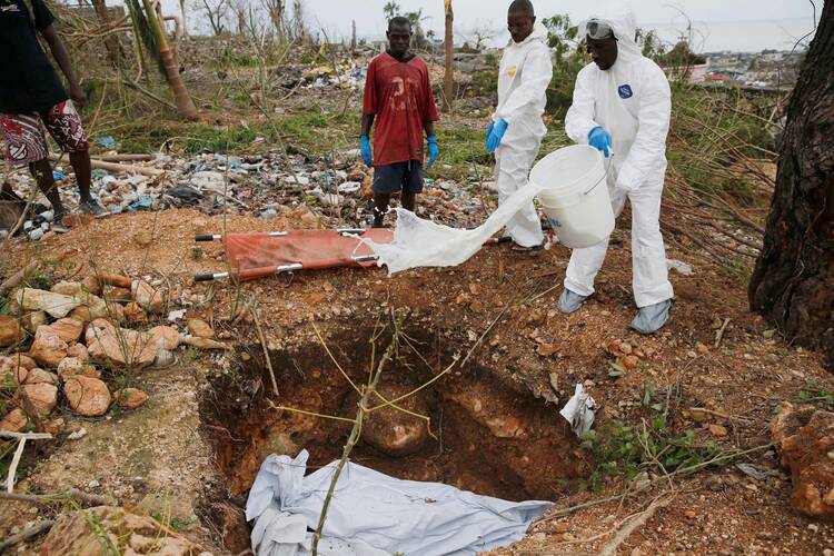 Workers bury bodies Oct. 6 after Hurricane Matthew, the most powerful Caribbean storm in nearly a decade, passed through Jérémie, Haiti. (CNS photo/Carlos Garcia Rawlins, Reuters) 