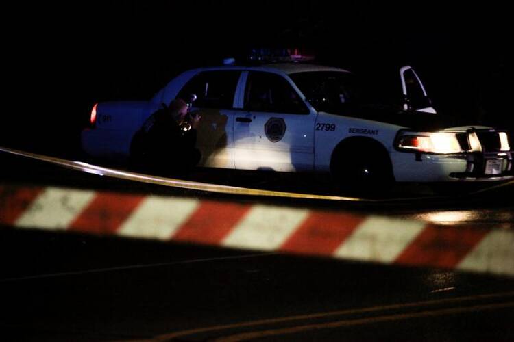 A police photographer takes pictures of bullet holes in a Des Moines, Iowa, police vehicle Nov. 2. Two police officers were shot and killed in separate attacks described as "ambush-style." (CNS photo/Brian Frank, Reuters)