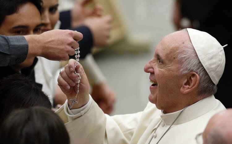  Pope Francis touches a rosary during his general audience in Paul VI hall at the Vatican Nov. 30. (CNS photo/Paul Haring) 