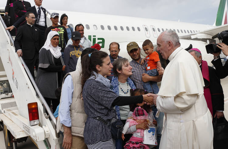 Pope Francis greets Syrian refugees he brought to Rome from the Greek island of Lesbos in April 2016 at Ciampino airport in Rome. (CNS photo/Paul Haring) 