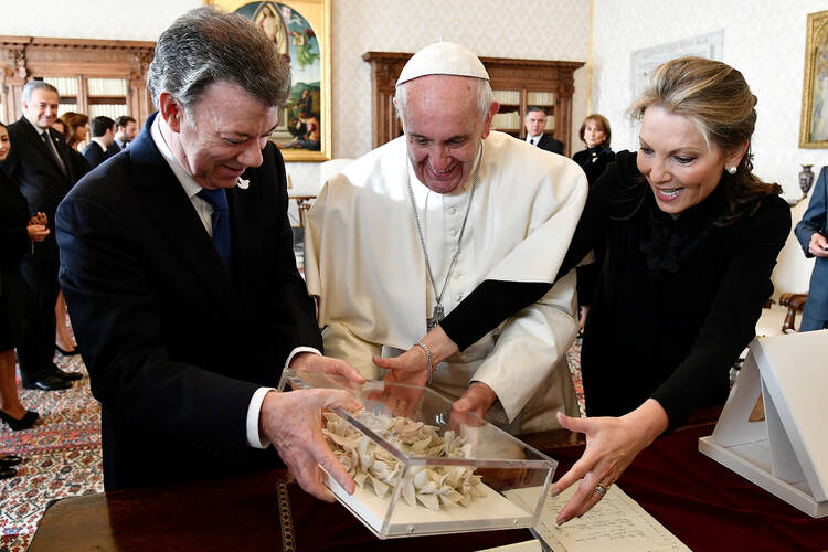 Pope Francis receives the "Bun of peace" at the Vatican Dec. 16 from Colombian President Juan Manuel Santos and his wife, Maria Clemencia Rodriguez. (CNS photo/Vincenzo Pinto, pool via Reuters)