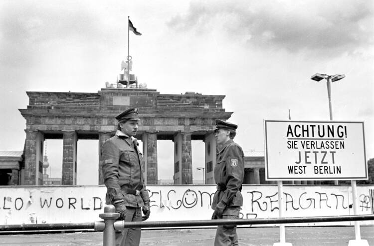 Border policemen stand next to the sign at the Berlin Wall and Brandenburg Gate in Berlin June 17, 1986. The sign says: "Achtung! Sie verlassen jetzt West-Berlin" (Attention, you are leaving West Berlin). (CNS photo/Wolfgang Kumm, EPA)