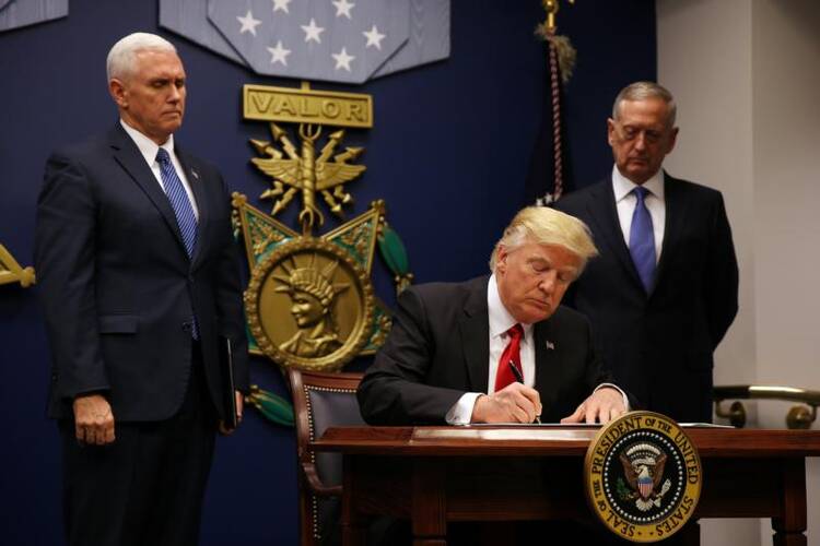 U.S. President Donald Trump signs a revised executive order for a U.S. travel ban March 6 at the Pentagon in Arlington, Va. The executive order temporarily bans refugees from certain majority-Muslim countries, and now excludes Iraq. (CNS photo/Carlos Barria, Reuters) 