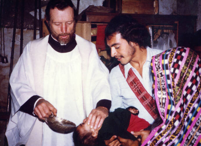 Father Stanley Rother, a priest of the Oklahoma City Archdiocese who was brutally murdered in 1981 in the Guatemalan village where he ministered to the poor, is shown baptizing a child in this undated photo. (CNS) 