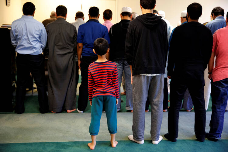 A boy attends afternoon prayer in 2016 at a mosque in Sterling, Va. An update to a 2016 study on Catholic perceptions of Islam shows that three in 10 Catholics admit to having unfavorable views about Muslims. (CNS photo/Carlos Barria, Reuters)