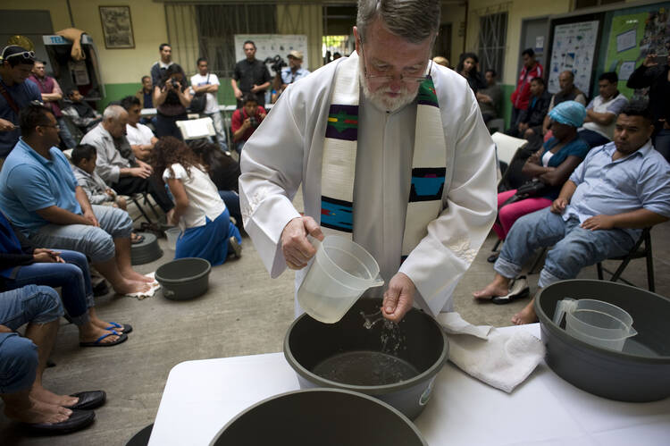 Father Pat Murphy, director of the Scalabrini-run Casa del Migrante shelter, washes his hands during a symbolic washing of feet for migrants on Holy Thursday April 13, 2017, in Tijuana, Mexico.(CNS photo/David Maung)