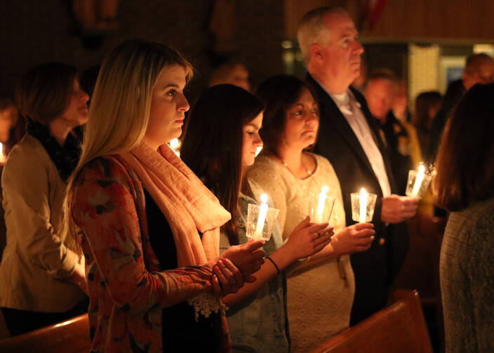 Worshippers hold candles at the beginning of the Easter Vigil at St. Louis de Montfort Church in Sound Beach, N.Y., in April 2017. (CNS photo/Gregory A. Shemitz)