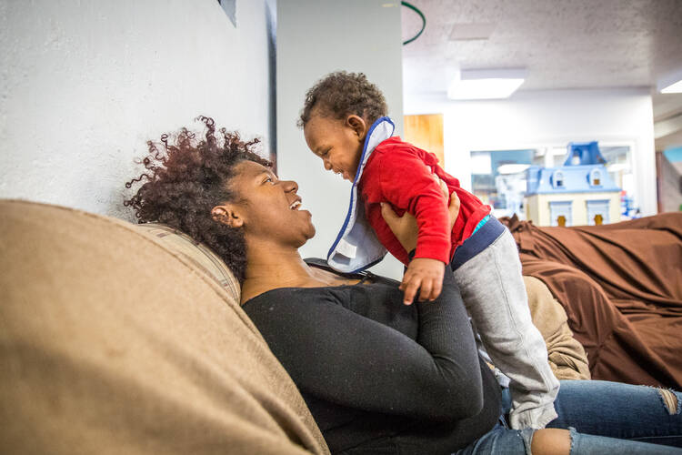 A woman plays with her 1-year-old son at Our Lady's Inn maternity home in St. Louis. African-American women suffer rates of maternity-related mortality three times higher than white women. (CNS photo/Lisa Johnston, St. Louis Review)