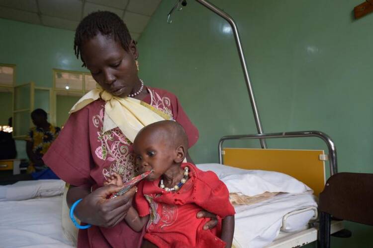 Ajok Uogu feeds her 2-year old daughter, Awok, a nutritional supplement on April 26 in St. Daniel Comboni Catholic Hospital in Wau, South Sudan. (CNS photo/Paul Jeffrey)
