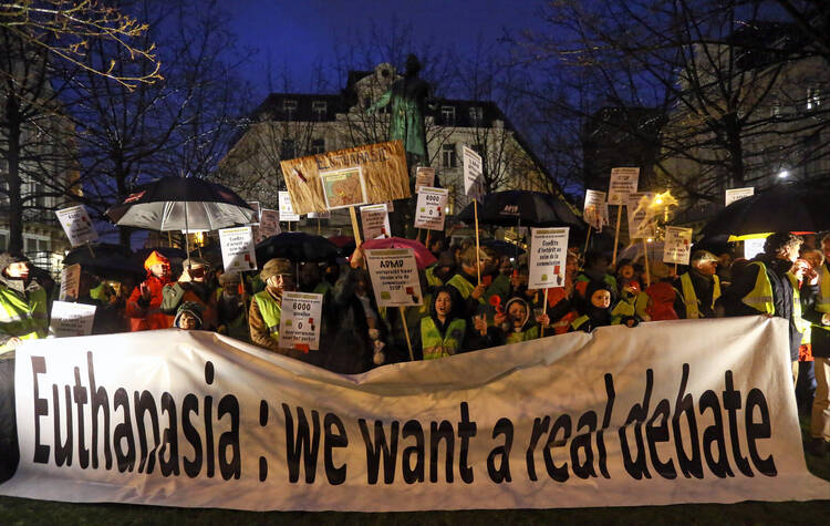 Activists of the collective Yellow Safety Jacket take part in an anti-euthanasia protest on Feb. 11, 2014, in Brussels. A group of psychiatric care centers run by a Catholic religious order in Belgium has announced it will permit doctors to undertake the euthanasia of "nonterminal" mentally ill patients on its premises. (CNS photo/Julien Warnand, EPA)