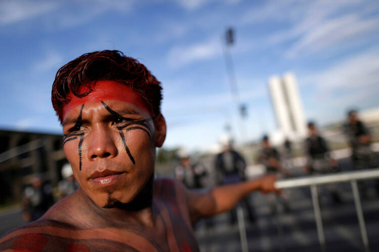 A Brazilian Indian in Brasilia takes part in a demonstration against the violation of indigenous rights on April 27. The Brazilian bishops' Indigenous Missionary Council criticized an April 30 attack in a remote area of Maranhao state that left 13 Gamela Indians injured. (CNS photo/Ueslei Marcelino, Reuters)