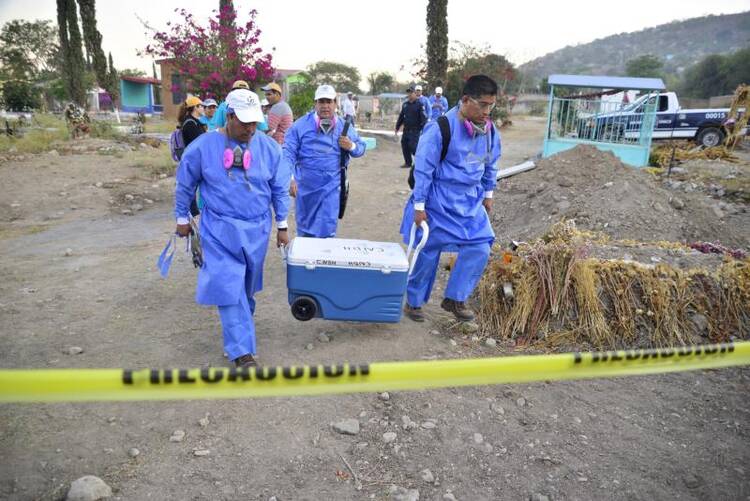 Specialists in Jojutla, Mexico, unearth remains found in unmarked graves on March 21. (CNS photo/Tony Rivera, EPA) 