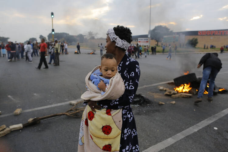 A mother and child join a housing and land protest in Johannesburg in May 2017. (CNS photo/Kim Ludbrook, EPA)