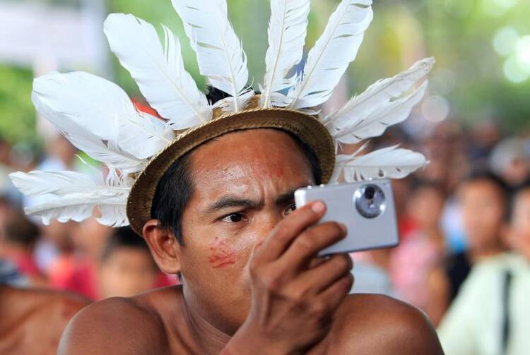 An indigenous member of the Desano ethnic group handles a camera during a meeting in Mitu, Colombia, on Aug. 19, 2016.  (CNS photo/Mauricio Duenas Castaneda, EPA)