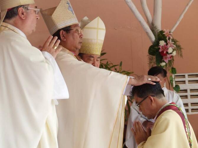 Cardinal-designate Louis-Marie Ling Mangkhanekhoun, apostolic vicar of Pakse, Laos, places his hands on a new bishop during a 2010 ordination Mass. (CNS CNS photo/UCAN handout via EPA)