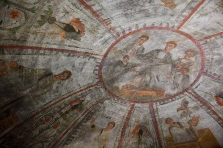 A fresco showing Noah releasing doves, lower right, and other scenes representing salvation are seen during the unveiling of two newly restored burial chambers in the Christian catacombs of St. Domitilla in Rome on May 30. (CNS photo/Carol Glatz) 
