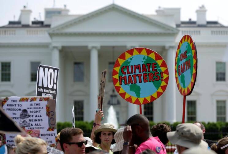 Protesters carry signs during the People's Climate March April 29 outside the White House in Washington. The U.S. bishops on June 1 urged President Donald Trump to honor the nation's commitment to the Paris climate pact and protect the planet. (CNS photo/Joshua Roberts) 