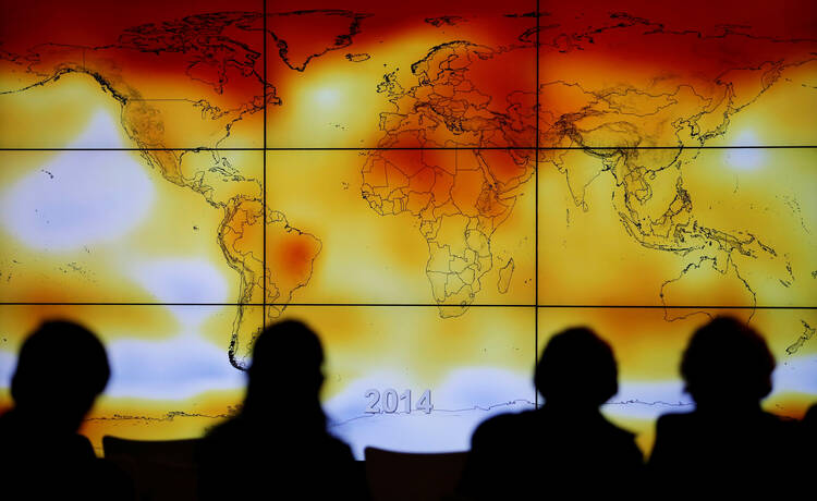 Participants look at a screen showing a world map with climate anomalies during the World Climate Change Conference at Le Bourge, France, in this Dec. 8, 2015, file photo. (CNS photo/Stephane Mahe, Reuters)