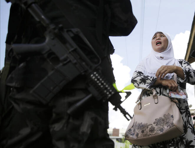 A Filipino woman speaks to a soldier at a checkpoint in Marawi, Philippines, on June 1. (CNS photo/Francis R. Malasig, EPA)