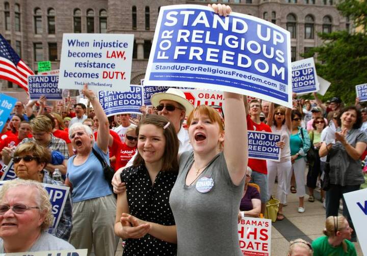  People display signs showing their support for religious freedom during a 2012 rally in downtown Minneapolis. It has been 20 years since the International Religious Freedom Act was passed by Congress and became law. (CNS photo/Dave Hrbacek, The Catholic Spirit)