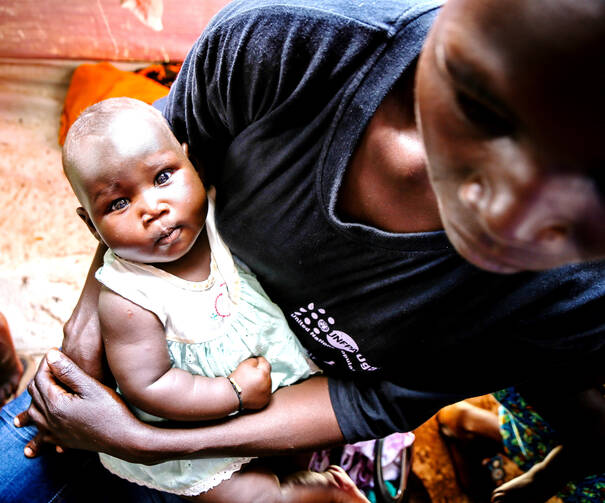 A mother cradles her baby May 30 at the Bidi Bidi refugee camp in Arua, Uganda, where thousands from war-ravaged South Sudan have fled in search of shelter and safety. (CNS photo/Helen Manson, U.S. Embassy in Uganda) 