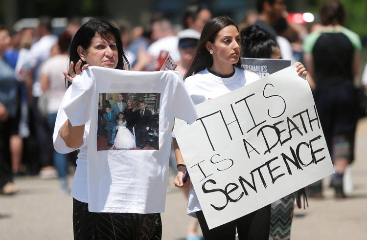 Chaldean-Americans protest on June 12 outside Mother of God Chaldean Catholic Church in Southfield, Mich., after dozens of Chaldean Christians were arrested by federal immigration officials over the weekend of June 10 and 11 in the Detroit metropolitan area. (CNS photo/Rebecca Cook, Reuters) 