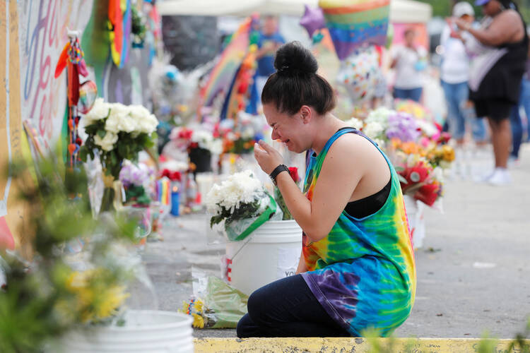 A woman cries while visiting the memorial outside the Pulse nightclub in Orlando, Fla., June 12, the one year anniversary of the mass shooting. The Diocese of Orlando broadcast via Facebook Live a prayer service attended by clergy of various faiths to remember the 49 who died June 12, 2016, during the largest mass shooting by a single gunman in the country's history. (CNS photo/Scott Audette, Reuters)