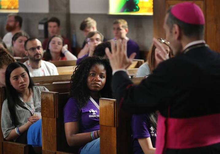 World Youth Day pilgrims listen as Bishop Frank J. Caggiano of Bridgeport, Conn., speaks in 2016 at Sacred Heart Church in Krakow, Poland. The October 2018 Synod of Bishops at the Vatican will focus on young people. (CNS photo/Bob Roller)