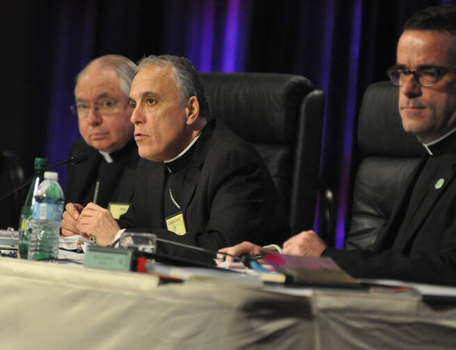 Cardinal Daniel N. DiNardo of Galveston-Houston, who is president of the U.S. Conference of Catholic Bishops, center, speaks on June 14 during the opening of the bishops' annual spring assembly in Indianapolis. (CNS photo/Sean Gallagher, The Criterion)