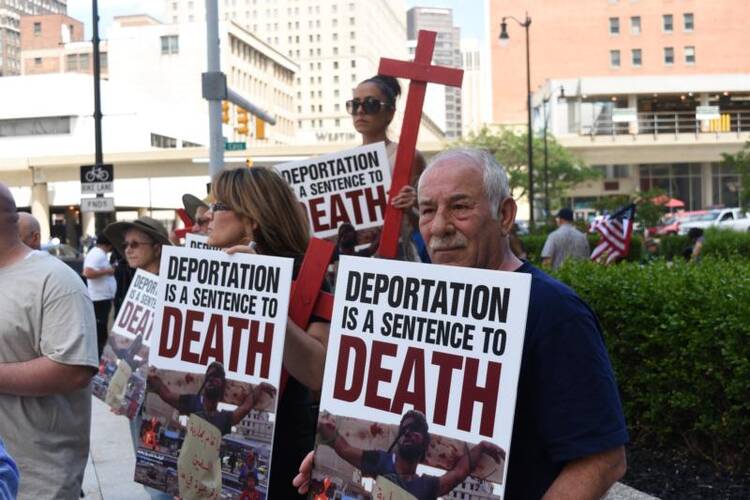 Members of the local Chaldean community gather outside the Patrick V. McNamara Federal Building on June 16 to protest the arrest and detention of more than 100 Chaldean Christians from the Detroit area. (CNS photo/Dan Meloy, The Michigan Catholic)
