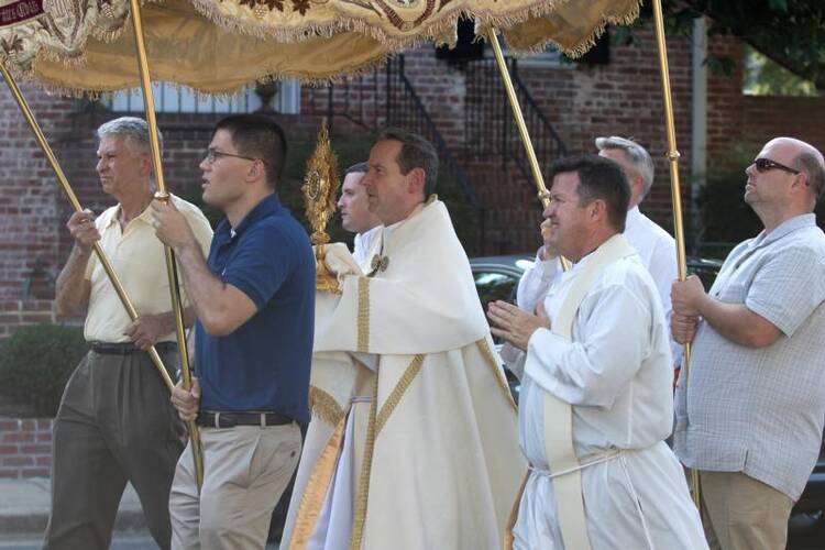 Bishop Michael F. Burbidge of Arlington, Va., carries a monstrance as he leads a Corpus Christi procession on June 18 outside St. Mary's Church in Alexandria. (CNS photo/Joe Cashwell, Arlington Catholic Herald) 