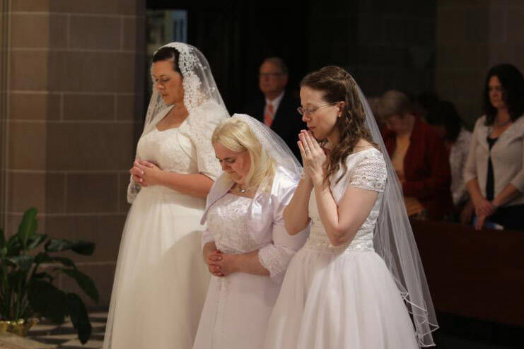 Karen Ervin, Theresa Jordan and Laurie Malashanko pause in prayer before the altar at the Cathedral of the Most Blessed Sacrament in Detroit on June 24. They were consecrated into the Catholic Church's order of virgins. (CNS photo/Joel Breidenbach)
