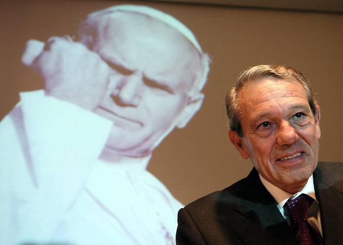 Joaquin Navarro-Valls, who spent 22 years as director of the Vatican press office, died on July 5 at age 80. He is pictured speaking in 2004 alongside a projected image of St. John Paul II. (CNS photo/Arne Dedert, EPA)