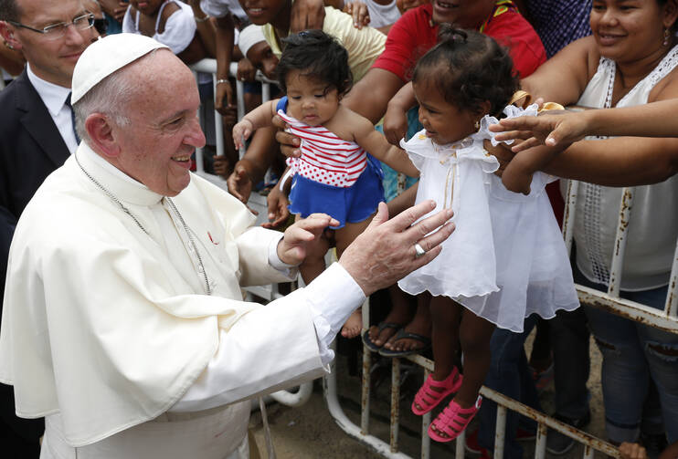 Pope Francis greets people near the Talitha Qum homeless shelter in Cartagena, Colombia, Sept. 10. The pope cut his head in the popemobile when it braked suddenly. (CNS photo/Paul Haring) 