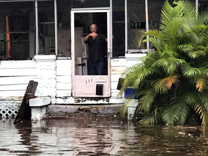 A man signals to police officers from a flooded house after Hurricane Irma passed through Daytona Beach, Fla. (CNS photo/Daytona Beach Police Department handout via Reuters)