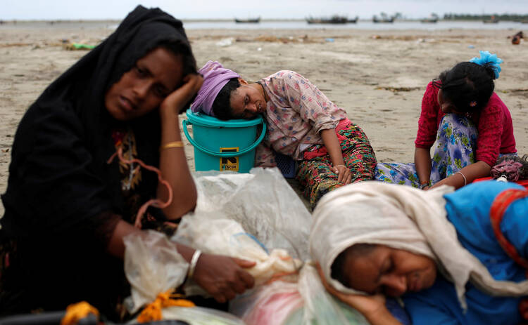 Exhausted Rohingya refugees rest on the shore in Shah Porir Dwip, Bangladesh, after crossing by boat through the Bay of Bengal on Sept. 10. (CNS photo/Danish Siddiqui, Reuters)