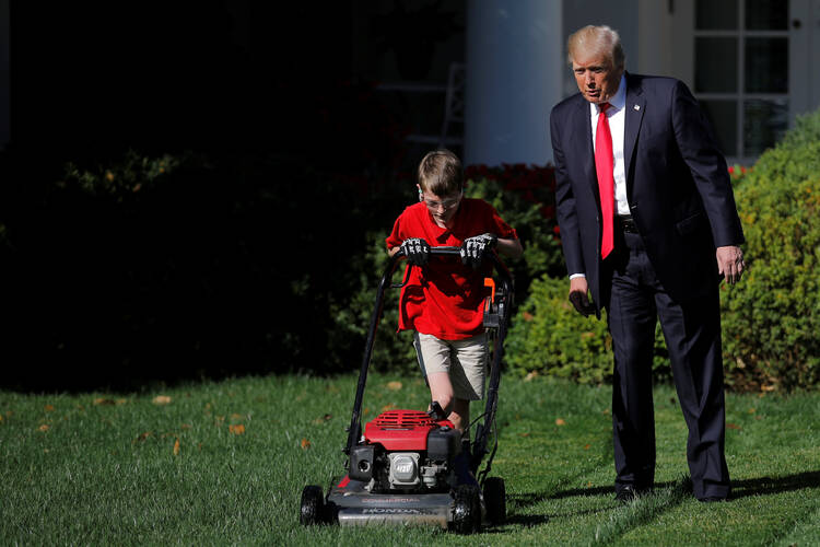 U.S President Donald Trump looks on as Frank Giaccio, an altar server at St. James Church in Falls Church, Va., mows the Rose Garden lawn on Sept. 15 at the White House in Washington. The 11-year-old, who wrote a letter to Trump offering to mow the White House lawn, was invited to work for a day at the White House. (CNS photo/Carlos Barria, Reuters)