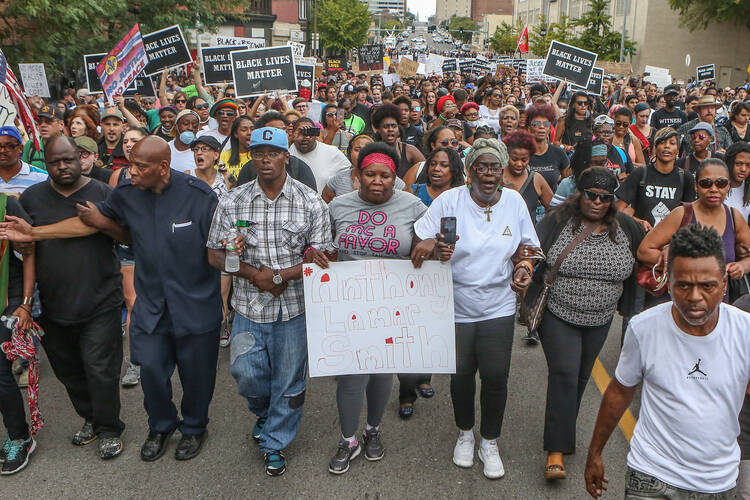 Anthony Lamar Smith's mother, Annie, center, walks with family and protesters during a peaceful rally on Sept. 17 after a not guilty verdict in the murder trial of former St. Louis police officer Jason Stockley, charged with the 2011 fatal shooting of Anthony Lamar Smith, who was black. Stockley is white. (CNS photo/Lawrence Bryant, Reuters)
