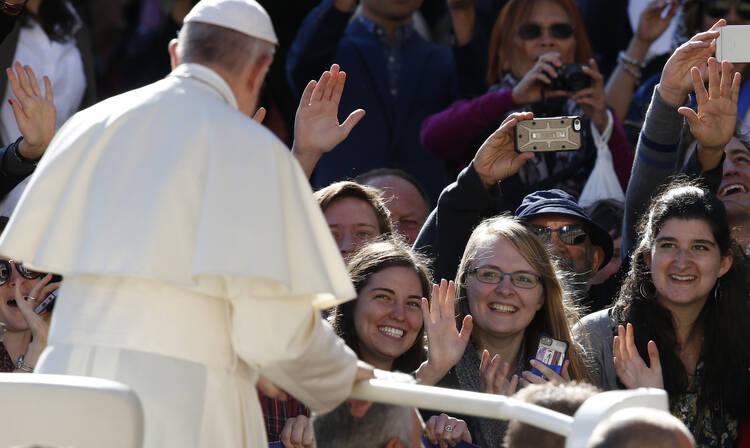 Young people wave as Pope Francis greets the crowd during his general audience in St. Peter's Square at the Vatican on Sept. 20. (CNS photo/Paul Haring)