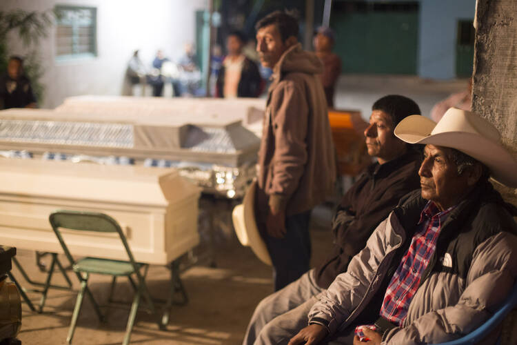 Residents mourn on Sept. 20 for the 11 victims killed in a church in Atzala, Mexico, during the Sept. 19 earthquake. A Catholic bishop in Mexico said the situation was extremely serious, and much aid would be needed. (CNS photo/Imelda Medina, Reuters)