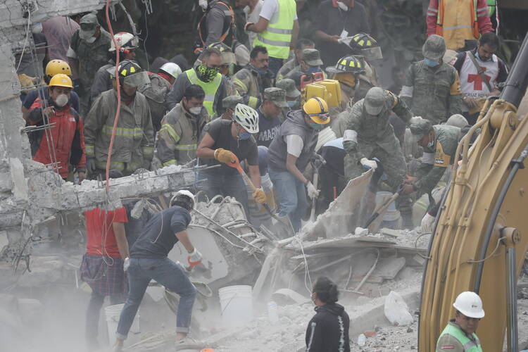 Rescue workers search for survivors in the debris of collapsed buildings Sept. 20 in Mexico City. The magnitude 7.1 earthquake hit Sept. 19 to the southeast of the city, killing hundreds. (CNS photo/Jose Mendez, EPA)