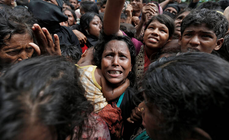 Rohingya refugees wait to receive aid Sept. 21 at a camp in Cox's Bazar, Bangladesh. (CNS photo/Cathal McNaughton, Reuters)