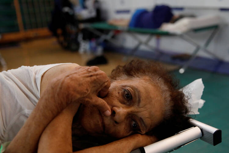 An elderly woman rests on Sept. 25 at a shelter set up in the Pedrin Zorrilla coliseum in San Juan, Puerto Rico, after the area was hit by Hurricane Maria. (CNS photo/Carlos Garcia Rawlins, Reuters)
