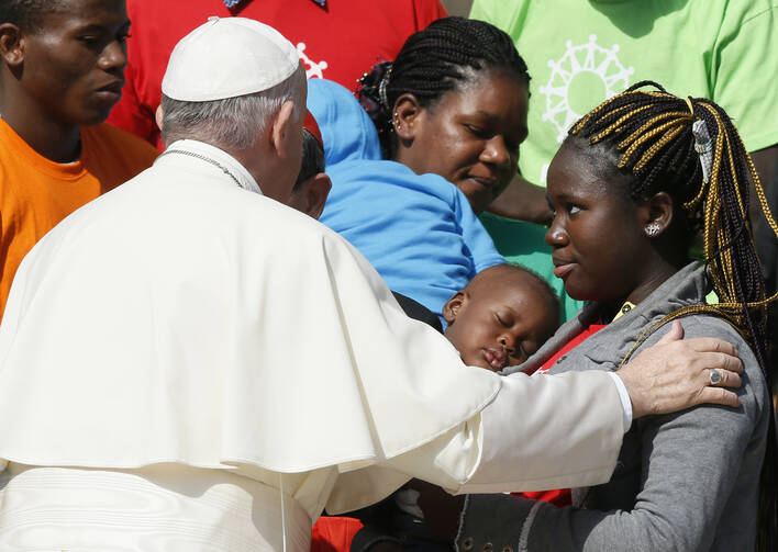 Pope Francis greets immigrants and representatives of Caritas Internationalis during his general audience in St. Peter's Square at the Vatican Sept. 27. (CNS photo/Paul Haring)