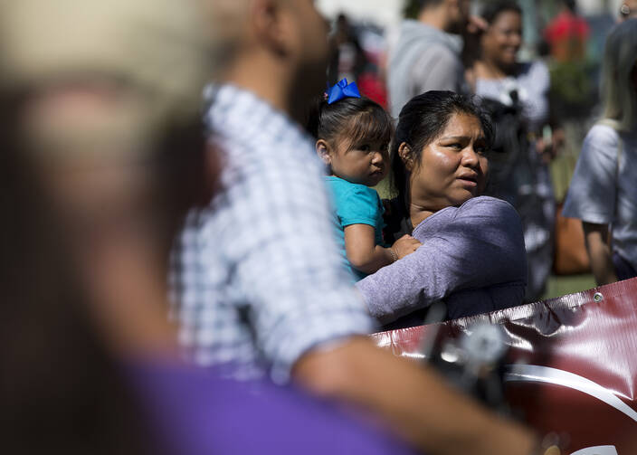 A woman holds a child during an immigration rally near the U.S. Capitol in Washington Sept. 26. (CNS photo/Tyler Orsburn)